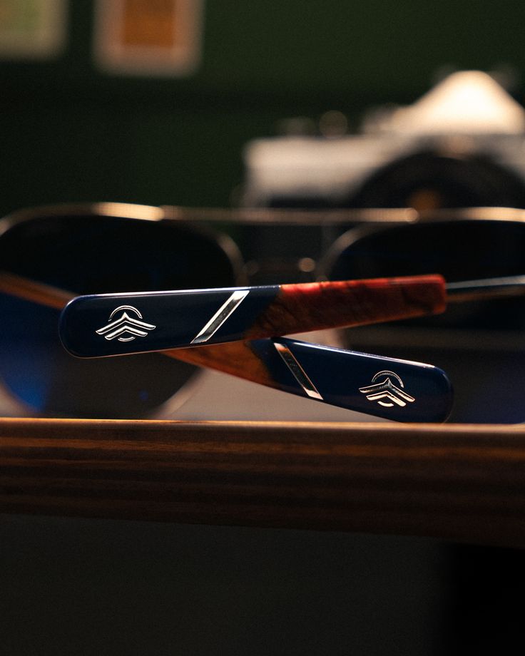 Detalle de las patillas personalizadas de gafas Randolph con acabado azul, madera y emblema grabado